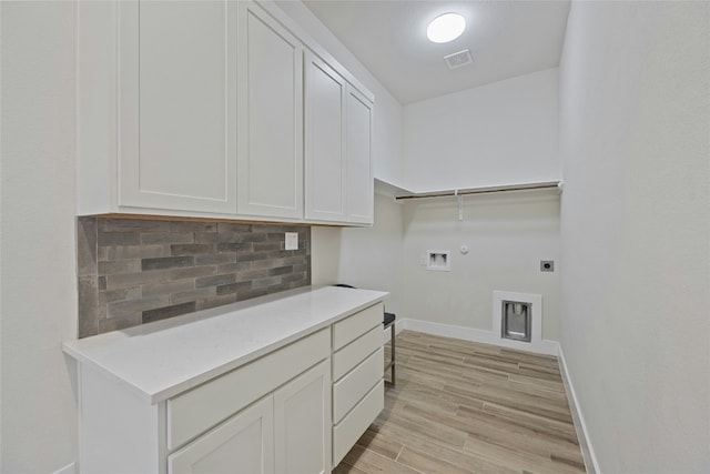 laundry room featuring electric dryer hookup, cabinets, gas dryer hookup, washer hookup, and light wood-type flooring