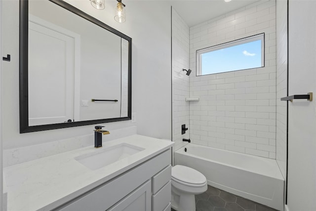 full bathroom with tile patterned floors, vanity, tiled shower / bath combo, and toilet