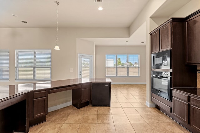 kitchen featuring built in desk, oven, hanging light fixtures, and black microwave