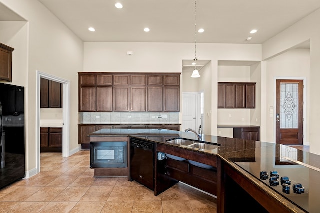 kitchen featuring sink, backsplash, decorative light fixtures, dark brown cabinets, and black appliances