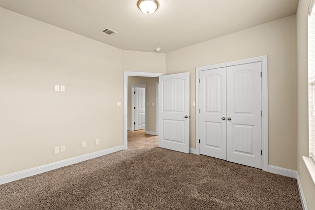 unfurnished bedroom featuring light carpet and a closet