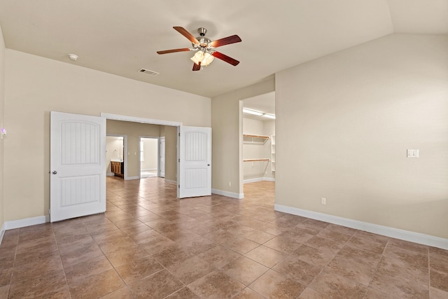 tiled empty room with vaulted ceiling and ceiling fan