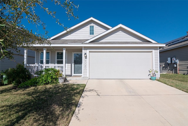 view of front of property with a front lawn, covered porch, and a garage