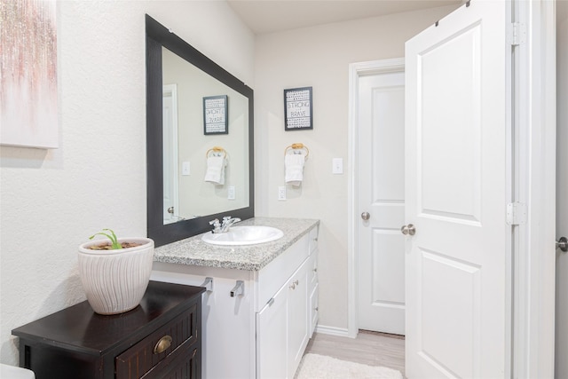 bathroom with hardwood / wood-style floors and vanity