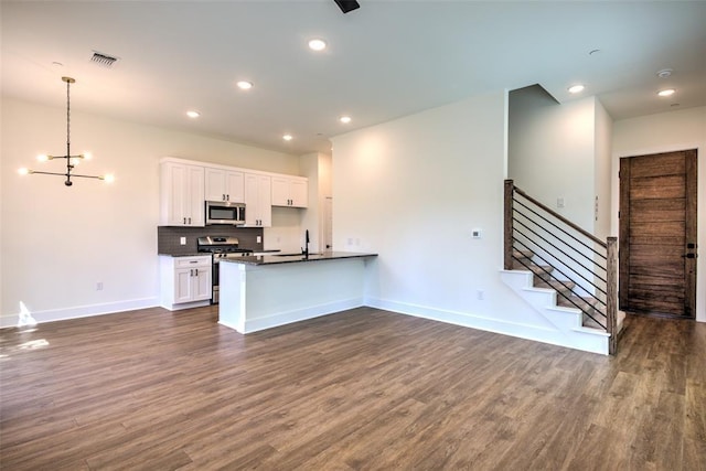 kitchen featuring decorative light fixtures, white cabinets, appliances with stainless steel finishes, and dark wood-type flooring