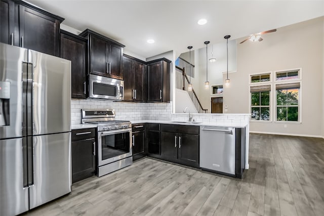 kitchen featuring pendant lighting, sink, light hardwood / wood-style flooring, ceiling fan, and appliances with stainless steel finishes