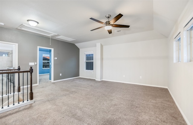 carpeted spare room with ceiling fan and lofted ceiling