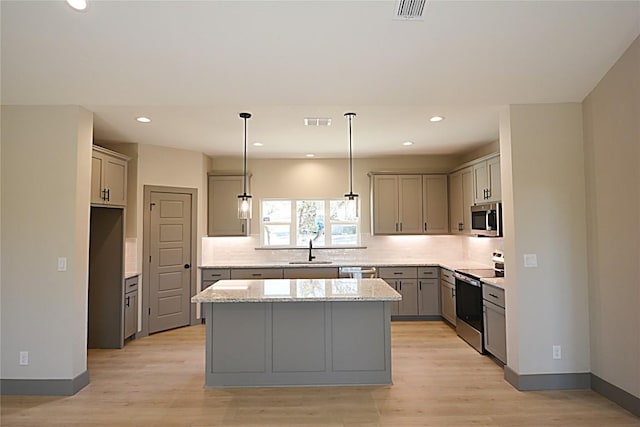 kitchen with sink, gray cabinets, stainless steel appliances, and a center island