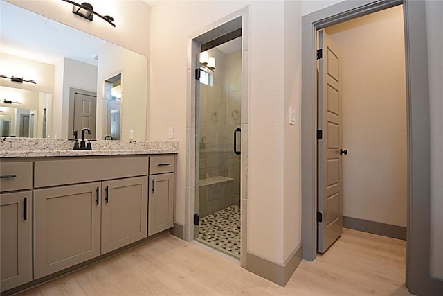 bathroom with vanity, wood-type flooring, and a shower with shower door