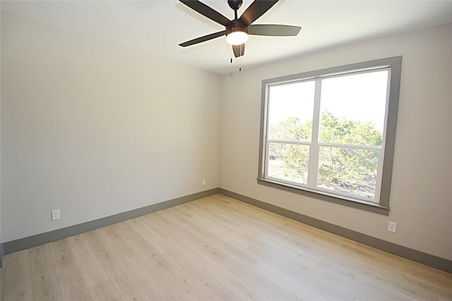 spare room with ceiling fan and light wood-type flooring