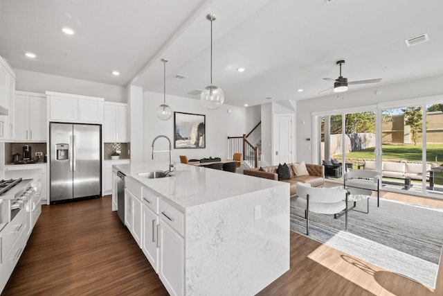 kitchen with appliances with stainless steel finishes, tasteful backsplash, sink, dark hardwood / wood-style floors, and white cabinetry