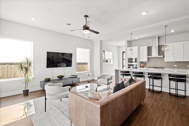 living room with ceiling fan and dark wood-type flooring