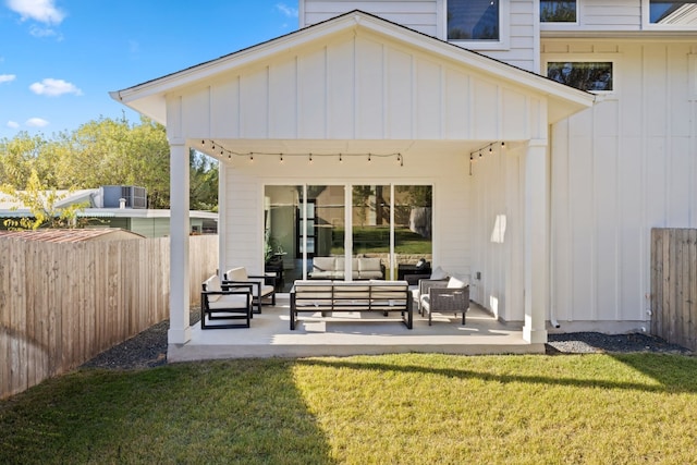 back of property with a lawn, a patio area, and an outdoor hangout area