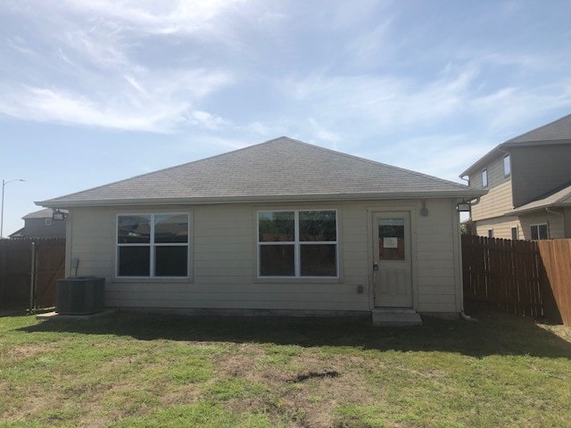 back of property featuring a yard and central AC