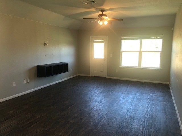 empty room featuring ceiling fan and dark wood-type flooring