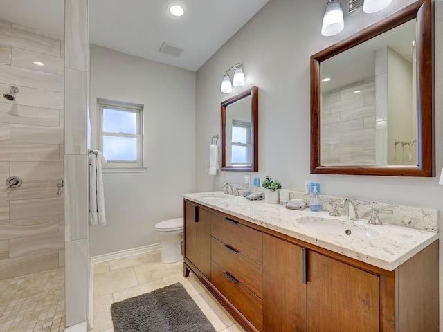 bathroom featuring tile patterned floors, vanity, toilet, and tiled shower