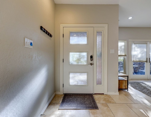 entrance foyer with light tile patterned floors and a healthy amount of sunlight