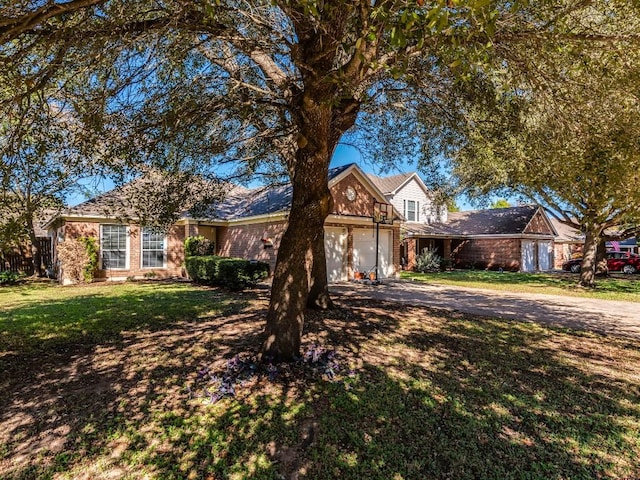 172 Winter St, Kyle, TX 78640 - view of front of house featuring driveway, an attached garage, a front lawn, and brick siding