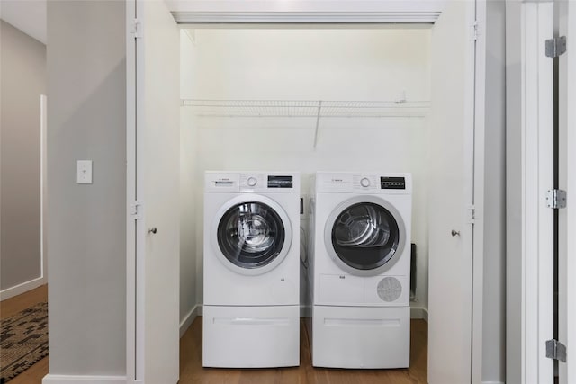 clothes washing area with light wood-type flooring and washing machine and clothes dryer