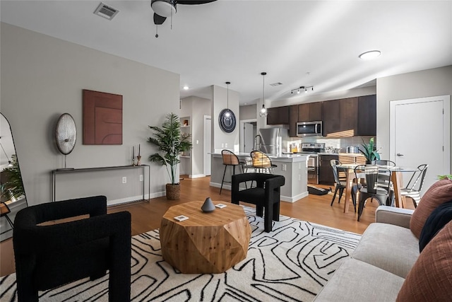 living room featuring light hardwood / wood-style flooring and ceiling fan