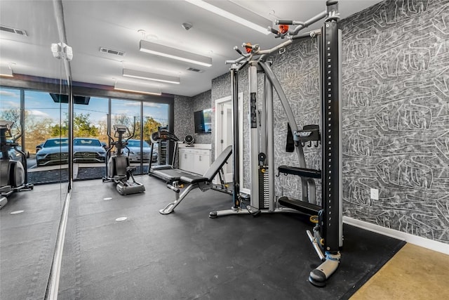 exercise room with wallpapered walls and expansive windows