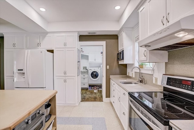 kitchen with sink, washer / clothes dryer, appliances with stainless steel finishes, white cabinets, and light wood-type flooring