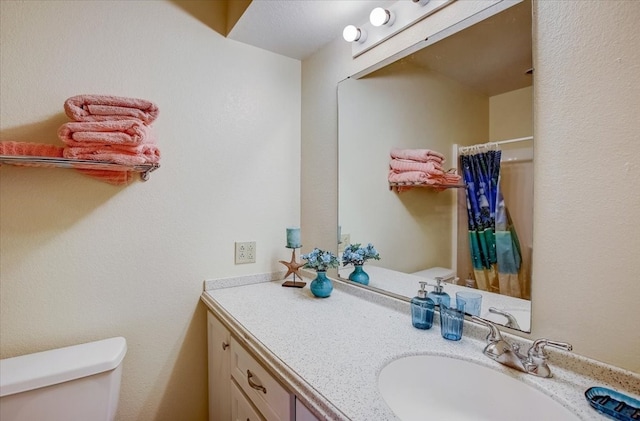 bathroom with vanity, curtained shower, and toilet