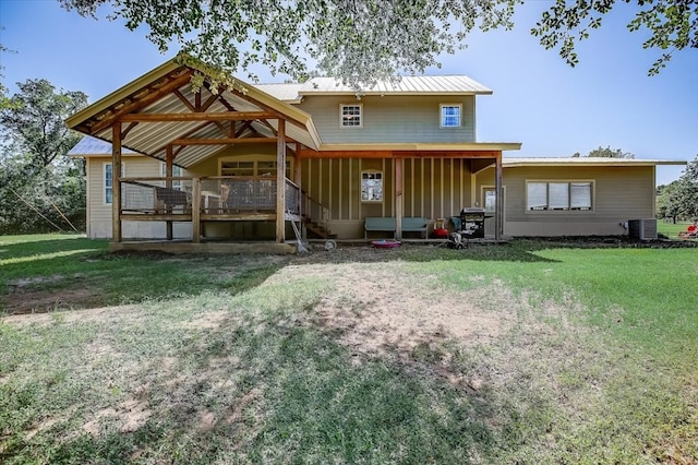 rear view of house with central air condition unit and a yard