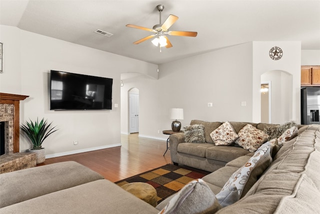 living room featuring a fireplace, dark hardwood / wood-style flooring, vaulted ceiling, and ceiling fan