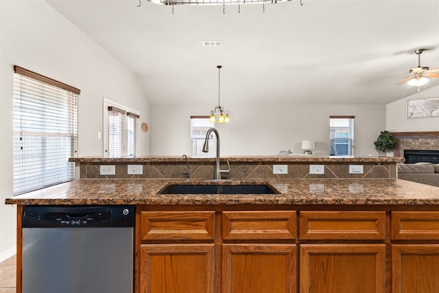 kitchen featuring stainless steel dishwasher, sink, a wealth of natural light, and vaulted ceiling