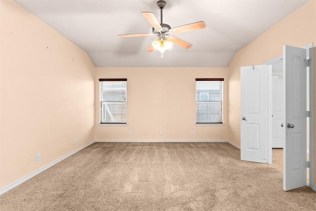 carpeted spare room with ceiling fan and lofted ceiling