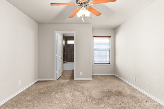 unfurnished bedroom featuring light carpet, connected bathroom, and ceiling fan