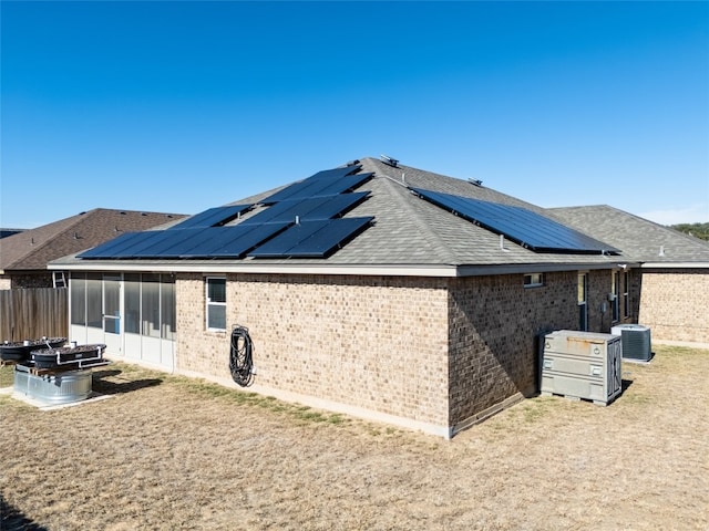 back of property with central air condition unit and a sunroom