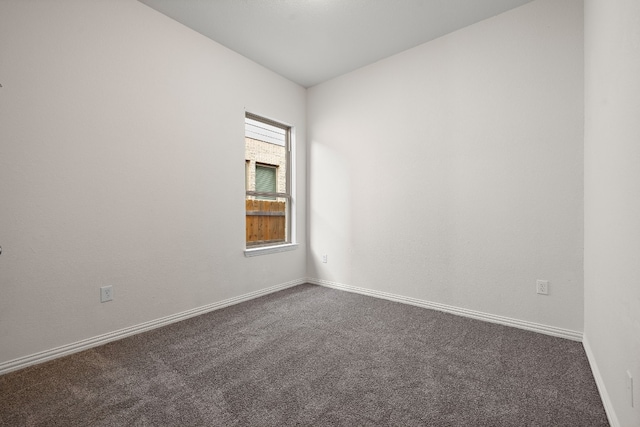 unfurnished room with dark colored carpet