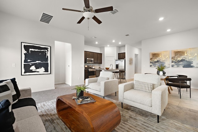 living room with tile patterned floors, ceiling fan, and sink