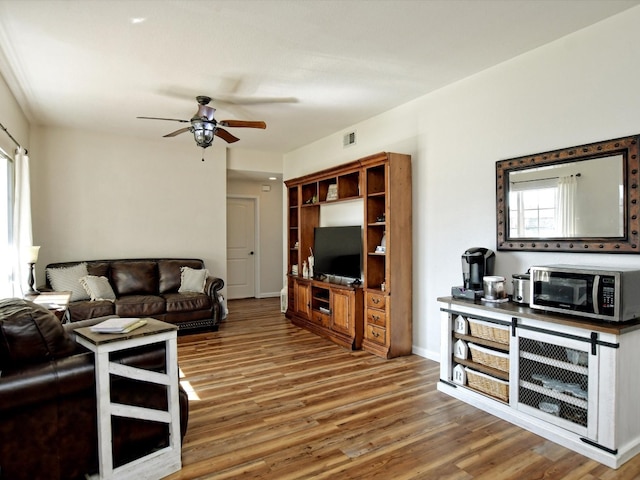 living room featuring ceiling fan and wood-type flooring