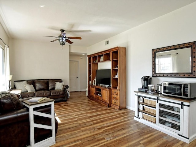 living room with hardwood / wood-style flooring, a wealth of natural light, and ceiling fan