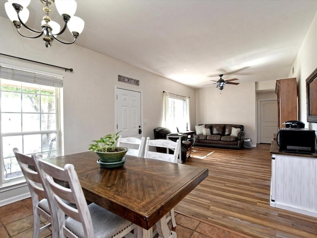 dining area featuring dark hardwood / wood-style floors and ceiling fan with notable chandelier