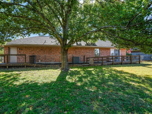 back of property featuring a wooden deck and a yard