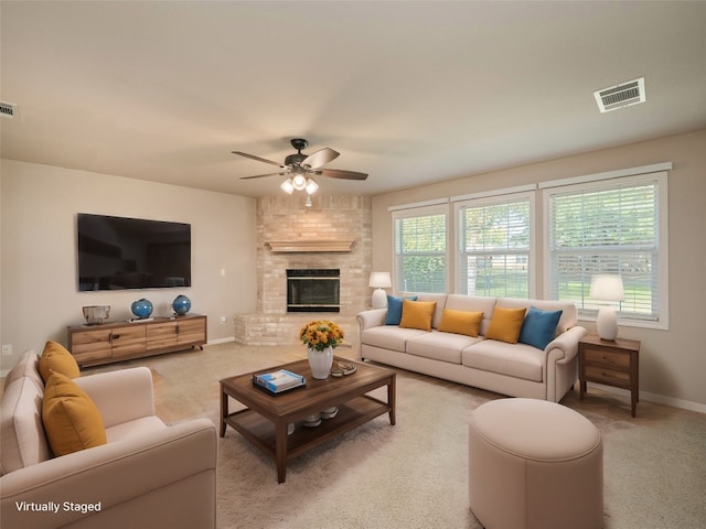 living room with ceiling fan, light colored carpet, and a brick fireplace