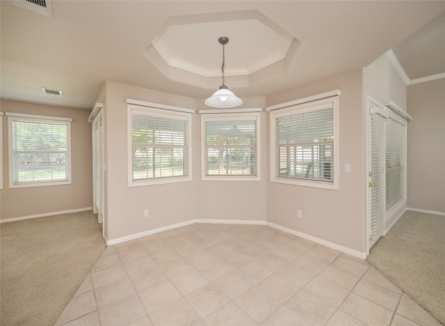 carpeted empty room featuring a tray ceiling and crown molding