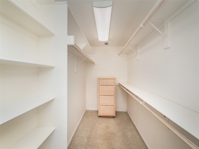 walk in closet featuring light colored carpet