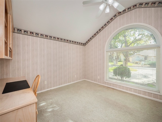 unfurnished office with ceiling fan, carpet, and vaulted ceiling