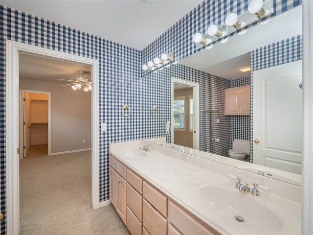 bathroom featuring vanity, toilet, and ceiling fan