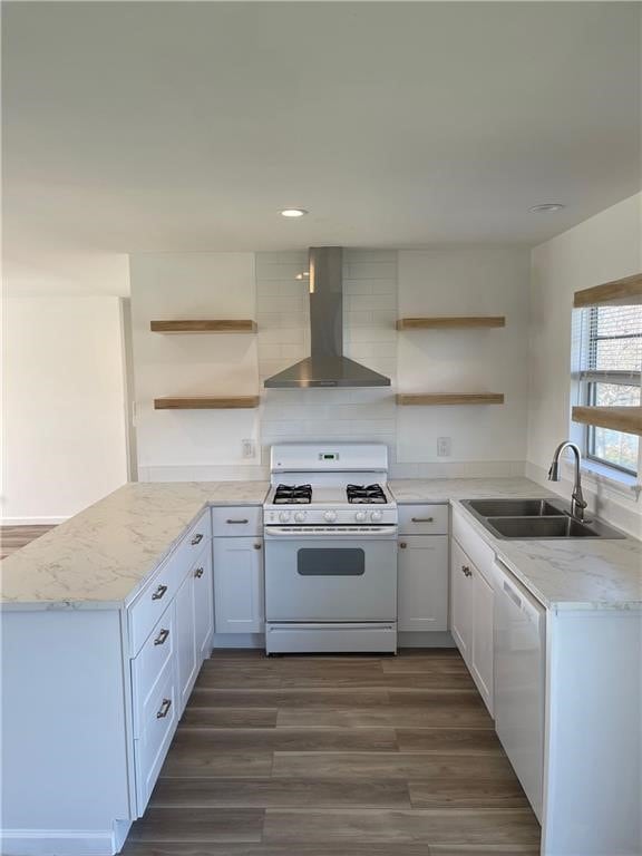 kitchen with white appliances, wall chimney range hood, sink, dark hardwood / wood-style floors, and white cabinetry