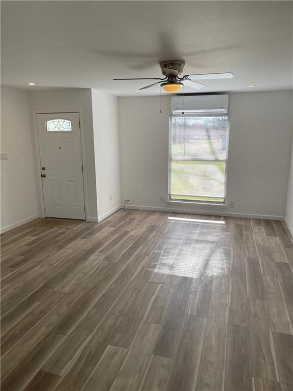 foyer featuring ceiling fan, a wall mounted air conditioner, and hardwood / wood-style flooring