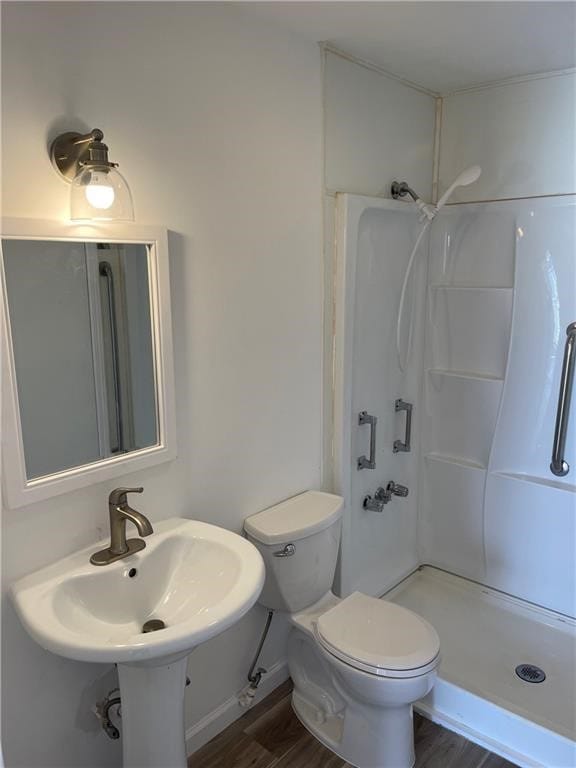 bathroom featuring sink, toilet, wood-type flooring, and a shower