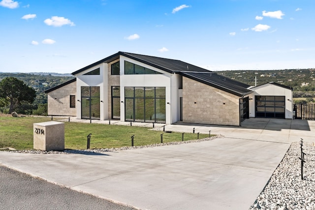 contemporary home featuring a garage and a front lawn