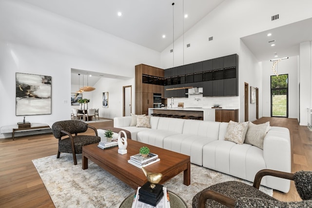 living room featuring light wood-type flooring and high vaulted ceiling