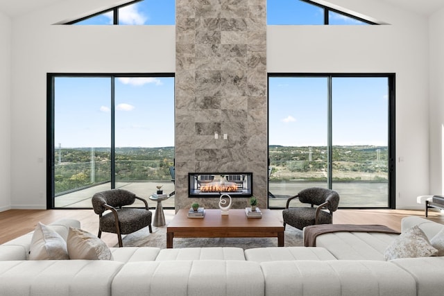 living room featuring hardwood / wood-style floors, a large fireplace, lofted ceiling, and a healthy amount of sunlight